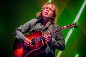 Billy Strings playing his guitar with the passion of a poet 